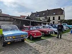 Un concours de voitures anciennes « Élégantes de Wissous » devant la grange aux Dîmes.