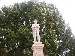 Vue d'une statue de soldat, tenant à ses pieds un fusil