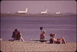 Plage au premier plan, aéroport à l'arrière-plan.
