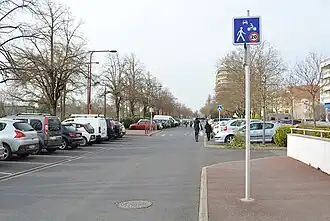 Contre-allée du boulevard avec des véhicules en stationnement