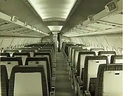 Cliché noir et blanc. Cabine passagers vers l'avant avec deux rangées de trois et deux sièges avec un couloir central