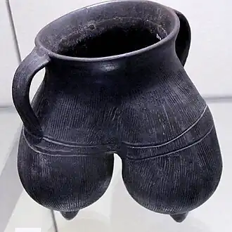 Vase à anses, tripode. Terre cuite grise à lustrage noir, décor excisé. H: 20&nbsp;cm env. Longshan (sans précision) , 2000-1700. Victoria and Albert Museum