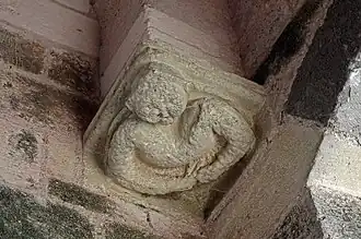 Photographie en couleurs d'un culot sculpté représentant un personnage sous une voûte.