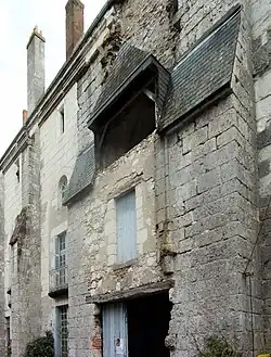 Photographie en couleurs d'un petit bâtiment en avancée dans un mur.
