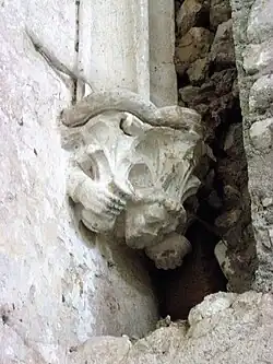 Photographie en couleurs d'une sculpture murale représentant un personnage.