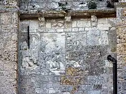 Photographie d'un bas-relief partiellement effacé.