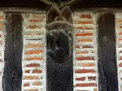 Photographie en couleurs d'un montant de bois gravé d'un animal fabuleux