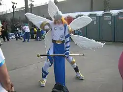 Homme caucasien dans un costume blanc et bleu comportant de fausses ailes