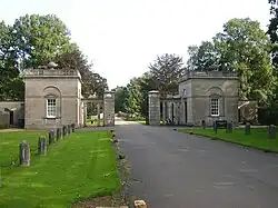 Photo. Entrée d'un domaine : grille d'entrée flanquée de deux pavillons