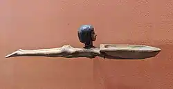 Cuiller en bois dont le manche représente le corps d'une femme. La tête de la femme marque l'articulation entre le manche et le creux, et le creux de la cuiller correspond aux bras de la nageuse.