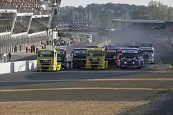 Vue de face du départ d'une course de camions sur le circuit des 24 heures du Mans