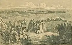 Une femme en embrasse une autre, au centre d'une foule de personnes.