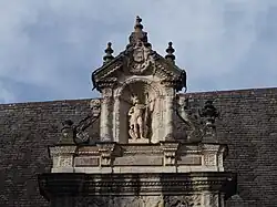Photographie en couleur d'un détail sculpté sur la façade d'un bâtiment.