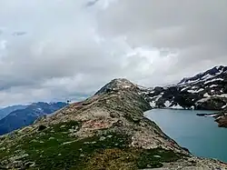 Le téléphérique en provenance de l'Alpe d'Huez (en photo sur la gauche) arrivant au pied du dôme des Petites Rousses au-dessus du lac Blanc.