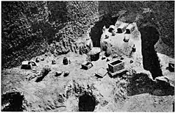 Photographie ancienne des fouilles d'une nécropole de Carthage avec divers artefacts dont des ossuaires encore en place