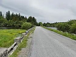 La RD 992 passe au-dessus du lac de Faux.