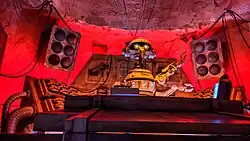 Robot levant les bras derrière une console.