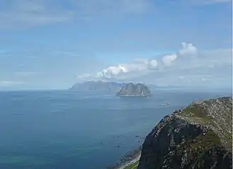 Mosken, vue depuis l'île de Værøy ; en arrière-plan, Moskenesøya.