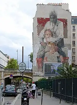 Franchissement de la rue par celle de Tolbiac (arche subsistante du viaduc de Tolbiac) ; à droite, la fresque Les trois âges de Conzalo Borondo réalisée en 2014.