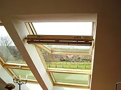 Fenêtre de toit de type Velux, dont l'axe de rotation n'est pas situé en haut de l'abattant.