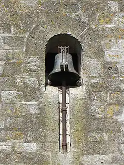 Cloche de l'église, sur le mur, avec deux marteaux