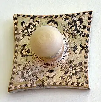 Carreau avec pommeau avec décor glaçuré représentant des motifs floraux, et inscription cunéiforme au nom d'Assurnasirpal II. Assur, Pergamon Museum.