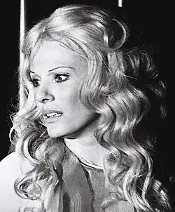 Photographie en noir et blanc du visage d'une jeune femme blonde aux traits anguleux.