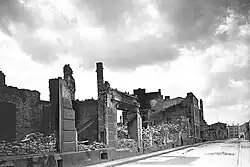 Photo en noir et blanc de ruines de maisons calcinées.