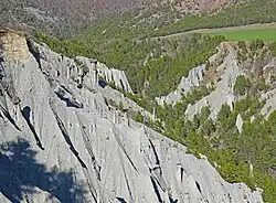 Photo montrant des aiguilles de roches coiffées d'un bloc d'une texture différente.