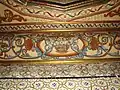 Gros plan sur une frise peinte de corbeilles de fleurs, de rinceaux et de coquilles.