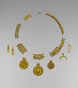 Perles en or formant un collier et pendentifs symbolisant des divinités trouvés dans le « trésor de Dilbat », milieu du IIe&nbsp;millénaire&nbsp;av. J.-C. Metropolitan Museum of Art.