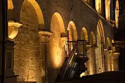 Photographie d'un mur d'église, décoré par des arcades murales.