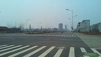 Route nouvelle surdimensionnée. Extension programmée de la ville sur la campagne résiduelle. Dingcheng, Changde, Hunan. 2014