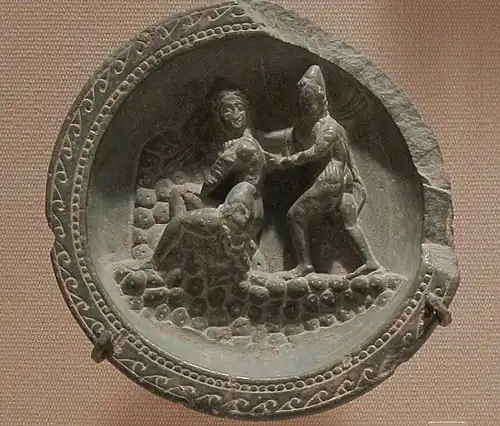 Palette à fard avec Apollon et Daphné. Schiste, d. 10,6&nbsp;cm. Gandhara, v. Ier&nbsp;siècle&nbsp;av. J.-C. Metropolitan Museum of Art