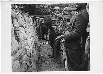 Tirailleurs de la Division marocaine tirant des fils de fer barbelé dans les tranchées.