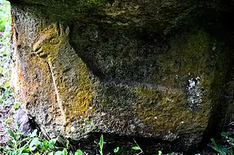 Bas-relief de chien marquisien sur le socle du tiki Makiʻi Tauʻa Pepe, dans le meʻae Iʻipona, village de Puamaʻu, île de Hiva Oa.