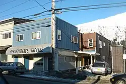 Ensoleillé, bâtiment gris au coin d'une intersection.