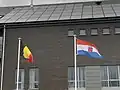 Le drapeau belge et le drapeau de la province de Luxembourg flottant devant l'Institut provincial de formation de Bastogne.