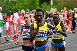 Au premier plan, Joan Melly courant avec le maillot jaune de la Roumanie. Derrière elle, Karoline Bjerkeli Grøvdal court avec le maillot bleu de la Norvège.