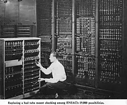 Un technicien en train de changer un tube de l'ENIAC