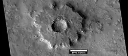 Cratère à piédestal, vu par HiRISE dans le programme HiWish. La couche supérieure a protégé les couches inférieures de l'érosion.