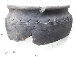 Haut d'une faïence grise et décorée d'un motif de vagues