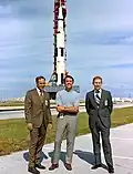 Mitchell (à gauche) et les autres membres de l'équipage Apollo 14 devant le lanceur Saturn V qui doit les envoyer sur la Lune.