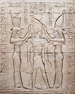 Ptolémée&nbsp;VIII en tenue de pharaon, entre les déesses Ouadjet et Nekhbet. Temple d'Horus à Edfou.