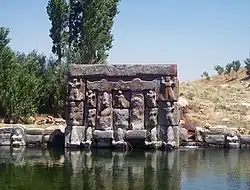 Le rocher sculpté d'Eflatun Pınar, situé sur un point d'eau sans doute pour être relié aux Enfers : le Dieu de l'Orage et la Déesse-Soleil entourés de divinités des montagnes et de disques solaires ailés.