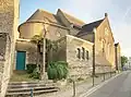 L'église Saint-Énogat avec son calvaire sur la rue Abbé Langevin.