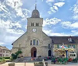 L’église Saint-Nithier avec un carrousel dans une ambiance estivale et légère.