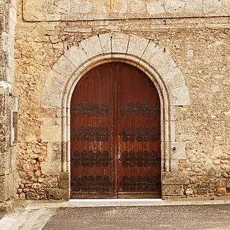Porte cintrée ornée de pentures.