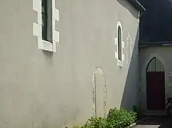 Photographie en couleur du murn d'un édifice percé de baies en plein cintre.