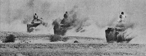 Photographie montrant trois chars égyptiens avançant à pleine vitesse sur une route du désert du Sinaï.